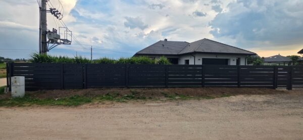 Przęsła z profili poziomych antracytowe RAL 7016 na podmurówce betonowej wzdłuż drogi, realizacja SILD